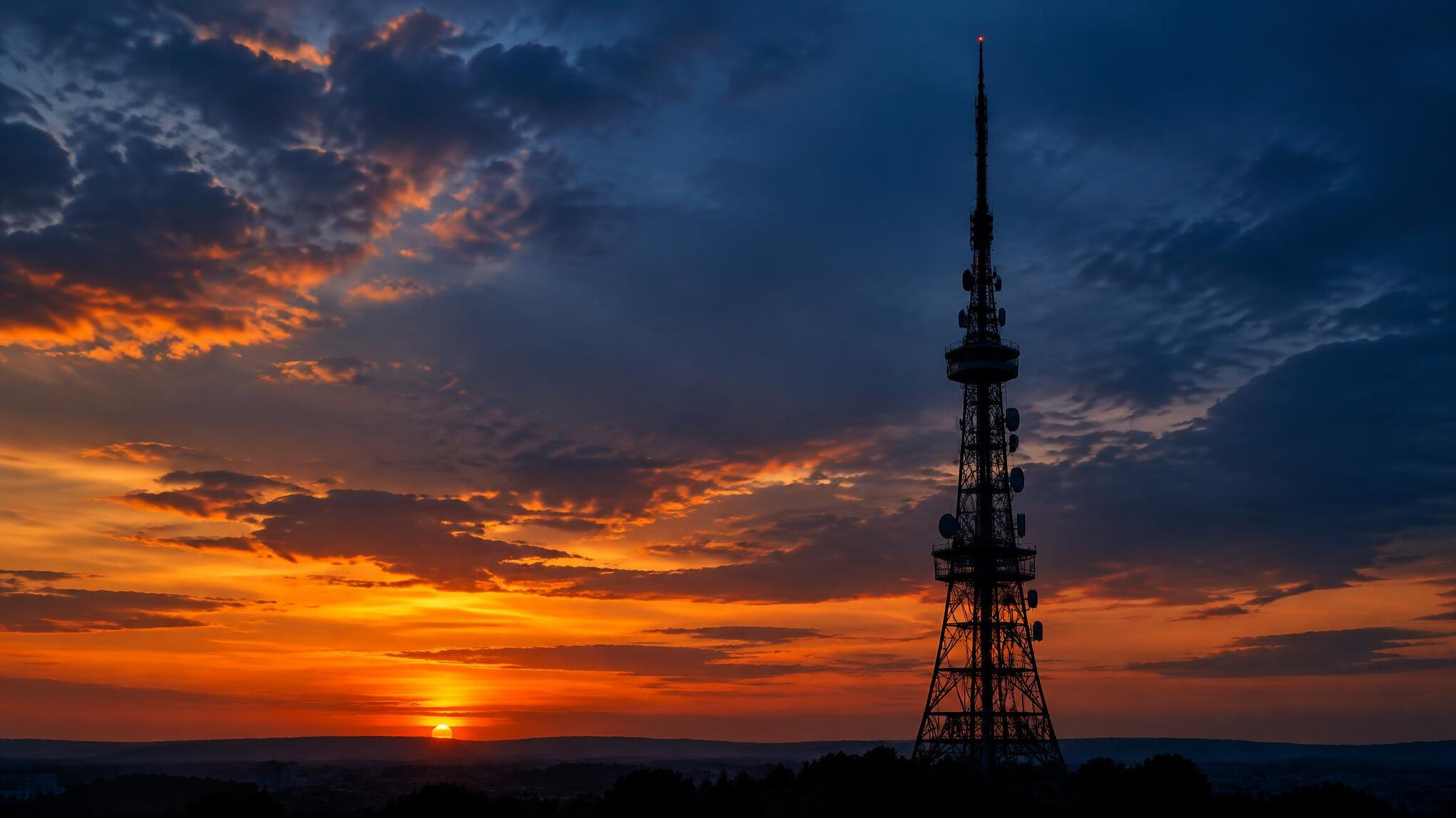 Television transmission tower against a dramatic evening sky